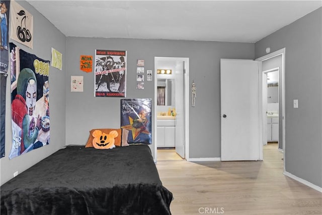 bedroom featuring light wood finished floors, connected bathroom, and baseboards