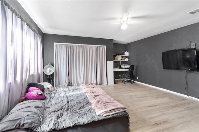 bedroom with baseboards, visible vents, ceiling fan, and light wood finished floors