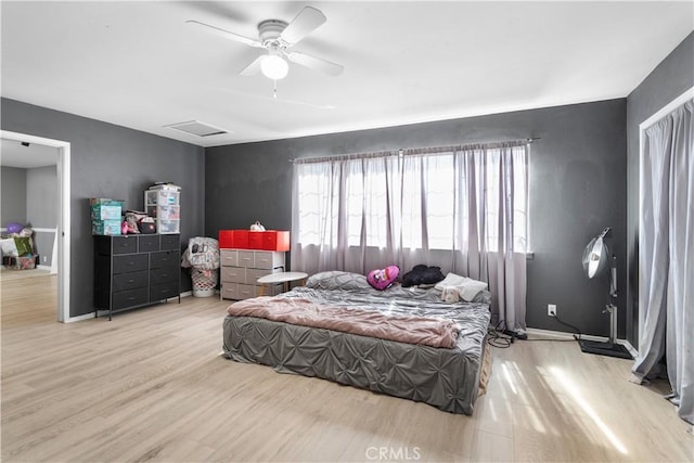 bedroom with baseboards, ceiling fan, light wood-style flooring, and attic access