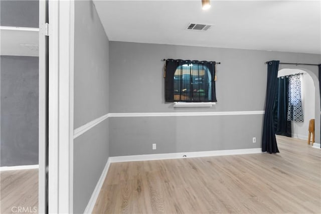 unfurnished room with light wood-style floors, baseboards, and visible vents