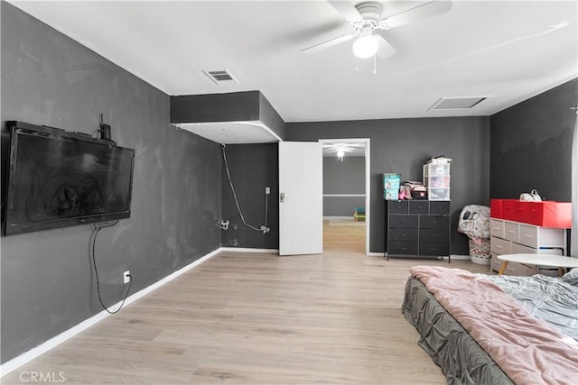 bedroom featuring visible vents, light wood-style floors, attic access, a ceiling fan, and baseboards