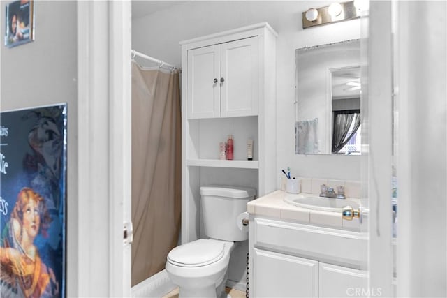 full bath featuring toilet, a shower with shower curtain, and vanity