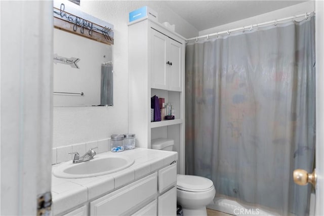 full bathroom featuring toilet, curtained shower, and vanity