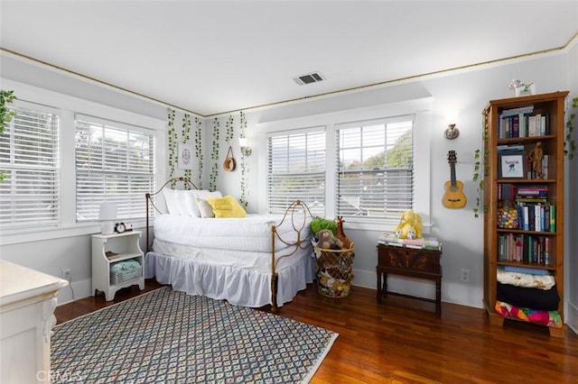 bedroom featuring multiple windows and dark hardwood / wood-style flooring