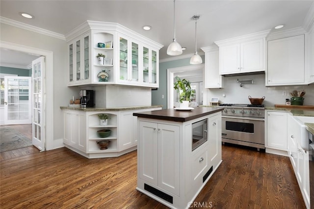 kitchen with dark hardwood / wood-style flooring, built in microwave, white cabinets, stainless steel stove, and hanging light fixtures