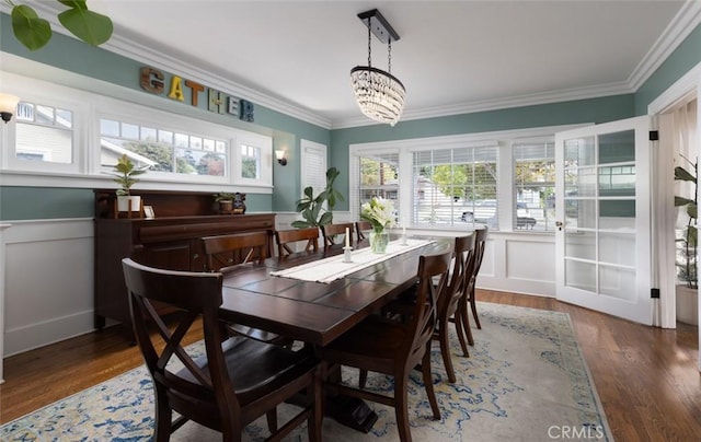 dining room featuring crown molding, dark hardwood / wood-style floors, and an inviting chandelier