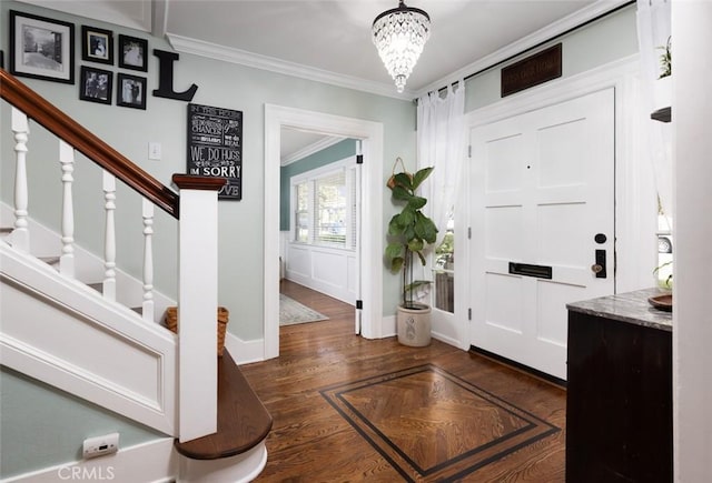 entrance foyer featuring dark hardwood / wood-style flooring, crown molding, and an inviting chandelier