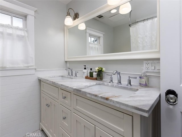 bathroom with vanity and tile walls