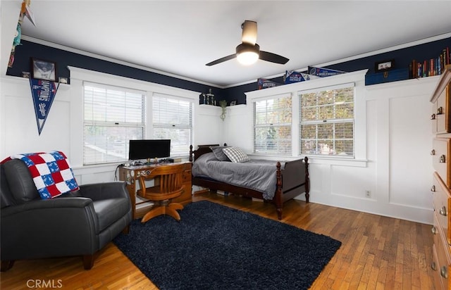 bedroom with multiple windows, hardwood / wood-style flooring, ceiling fan, and ornamental molding