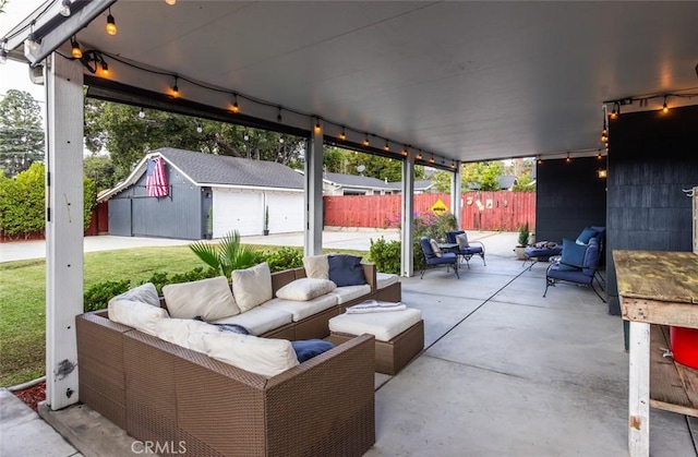 view of patio / terrace with outdoor lounge area, a garage, and an outdoor structure