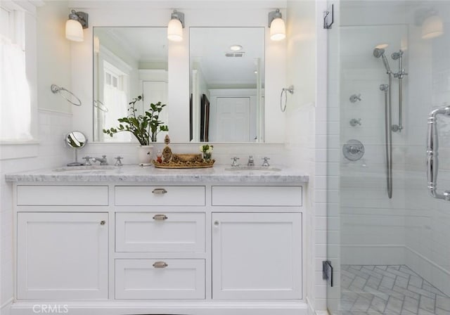 bathroom featuring vanity, an enclosed shower, and ornamental molding