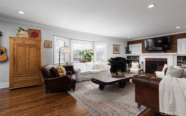 living room featuring dark wood-type flooring, crown molding, and a brick fireplace