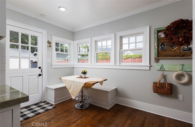 interior space with breakfast area, crown molding, and dark wood-type flooring