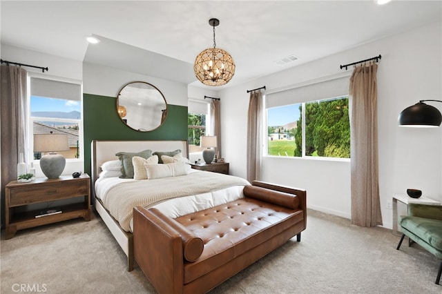 carpeted bedroom with an inviting chandelier