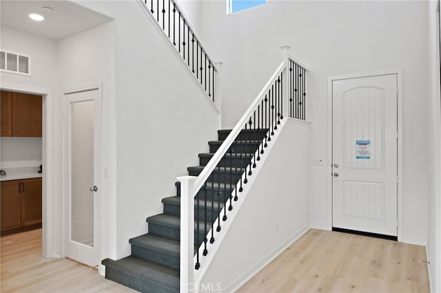 entryway with light hardwood / wood-style floors and a high ceiling