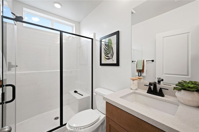 bathroom featuring vanity, toilet, and a shower with shower door