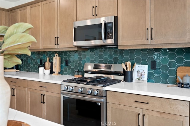 kitchen with appliances with stainless steel finishes and backsplash