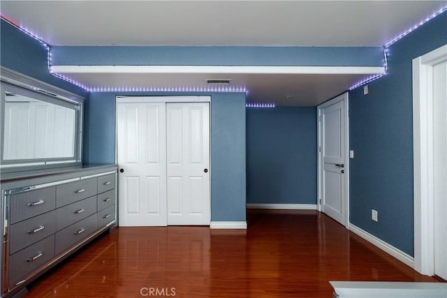 unfurnished bedroom featuring a closet and dark hardwood / wood-style flooring