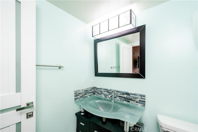 bathroom featuring decorative backsplash, vanity, and toilet