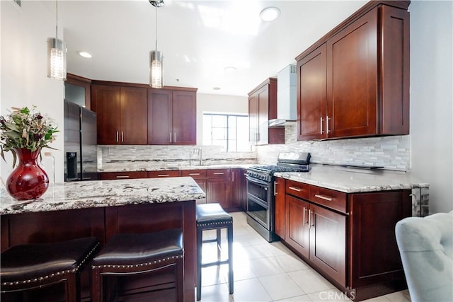 kitchen featuring gas stove, wall chimney exhaust hood, hanging light fixtures, black refrigerator with ice dispenser, and decorative backsplash