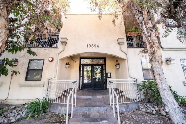 property entrance featuring a balcony and covered porch