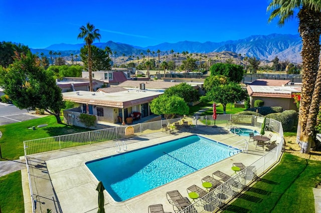 view of pool featuring a patio area, a mountain view, and a yard