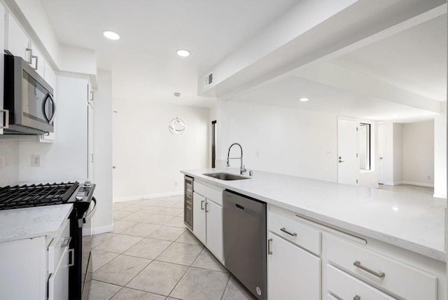 kitchen with pendant lighting, sink, light tile patterned floors, stainless steel appliances, and white cabinets