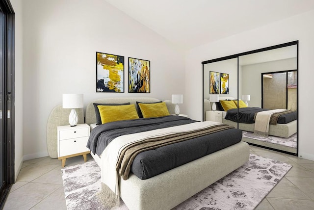 bedroom with vaulted ceiling, light tile patterned floors, and a closet