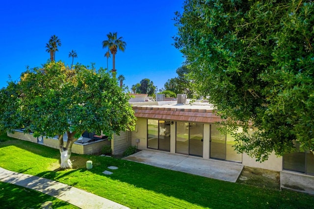 rear view of house with a yard and a patio