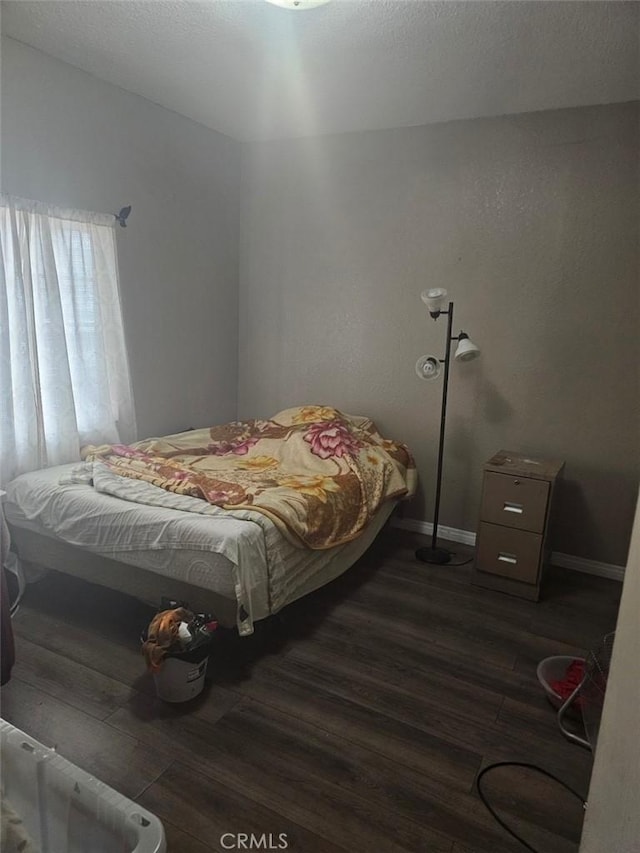 bedroom with dark hardwood / wood-style floors