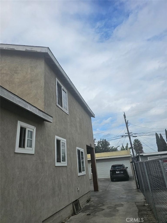 view of side of home with a garage and an outbuilding