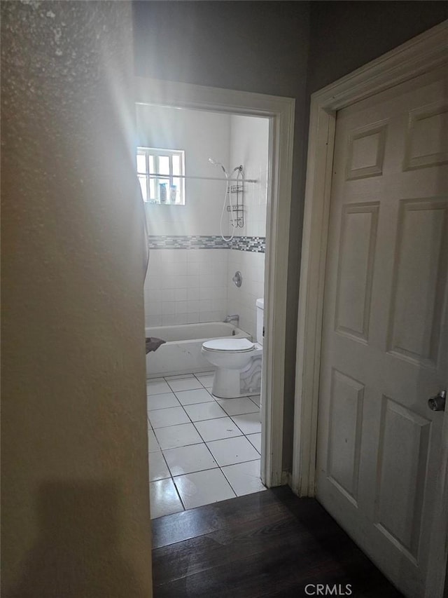 bathroom with tile patterned floors, toilet, and bathing tub / shower combination