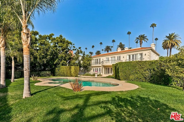 view of pool with a yard and french doors