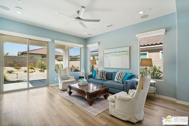 living room featuring ceiling fan, a wealth of natural light, and light hardwood / wood-style floors