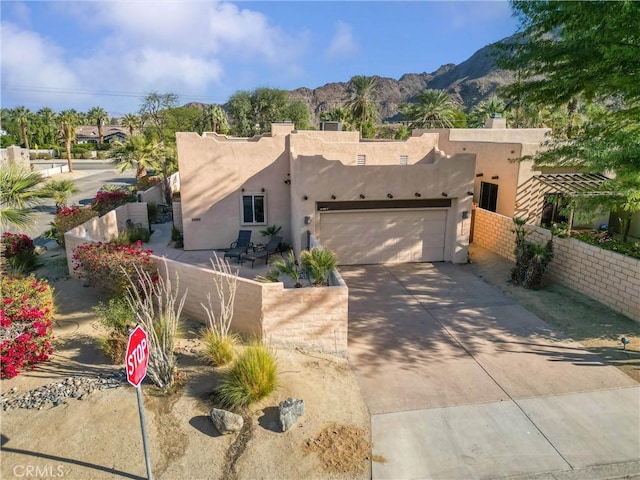 pueblo-style house featuring a mountain view and a garage