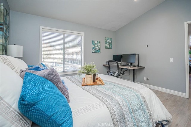 bedroom featuring wood-type flooring and vaulted ceiling