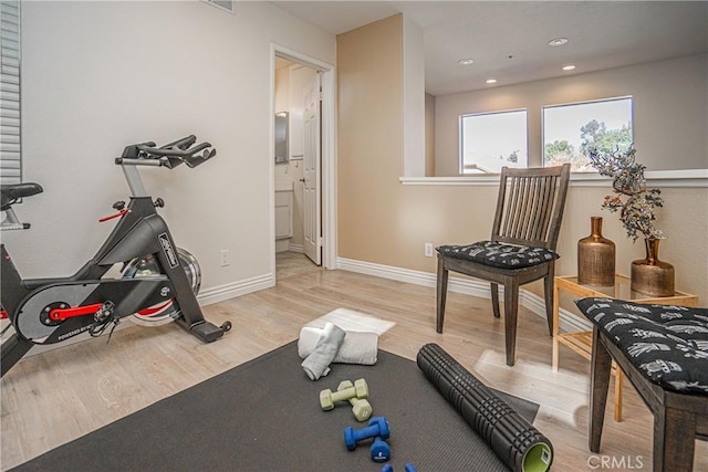 exercise room with light wood-type flooring