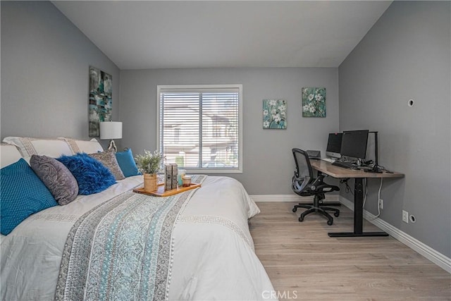 bedroom featuring light hardwood / wood-style flooring and vaulted ceiling