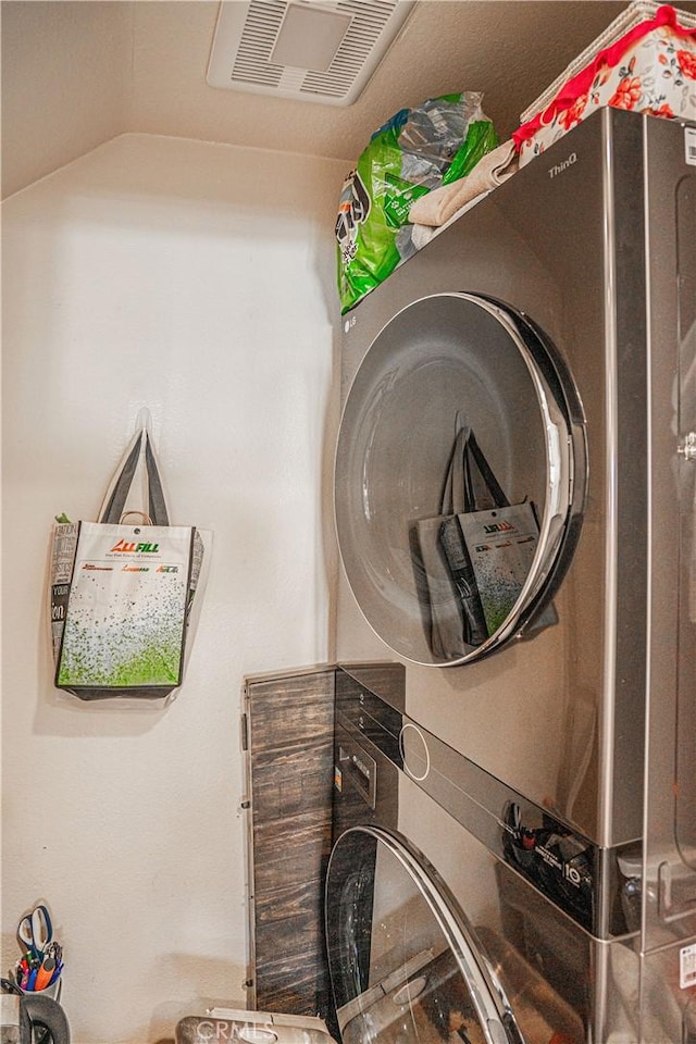 laundry area featuring stacked washer / drying machine