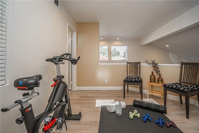 exercise area with lofted ceiling and light hardwood / wood-style floors