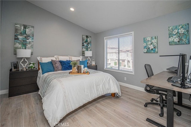 bedroom with lofted ceiling and light wood-type flooring