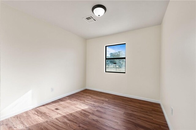 unfurnished room with hardwood / wood-style floors