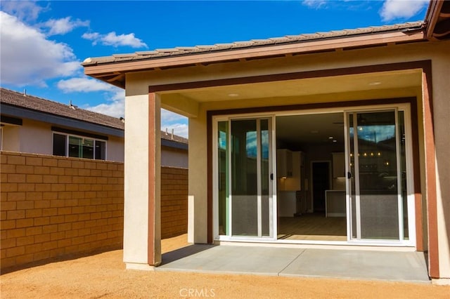 view of exterior entry with a patio