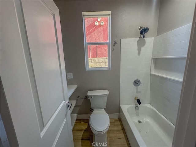 bathroom featuring bathing tub / shower combination, hardwood / wood-style floors, and toilet