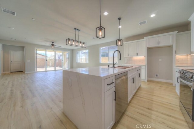 67837 Rio Vista Dr, Cathedral City, CA 92234 - kitchen with a sink, stainless steel appliances, backsplash, light wood-style flooring, and a ceiling fan