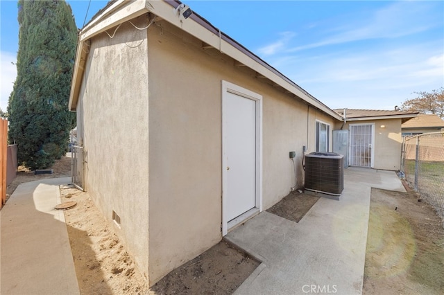 view of side of home with a patio area and central AC unit