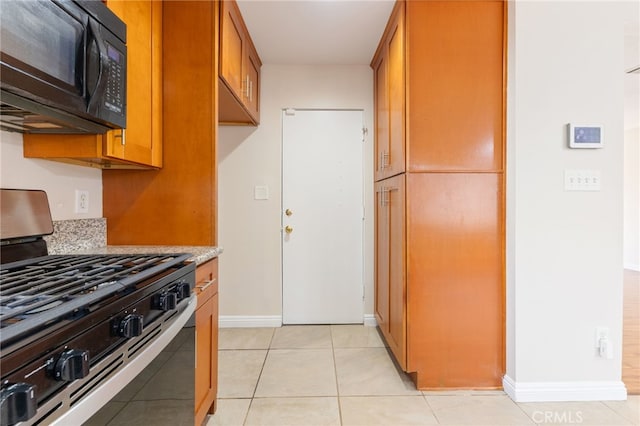 kitchen with light tile patterned floors and stainless steel range with gas stovetop