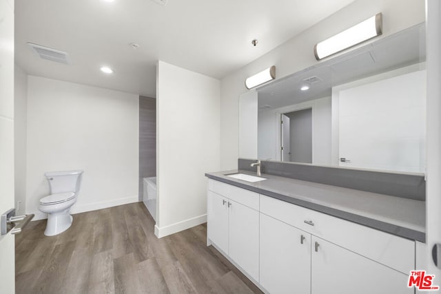 full bathroom featuring vanity, hardwood / wood-style flooring, toilet, and  shower combination