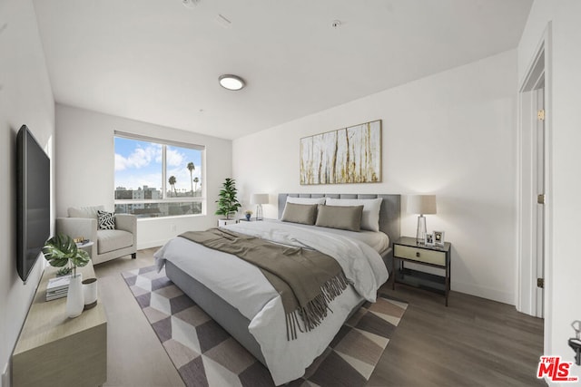 bedroom with dark hardwood / wood-style floors