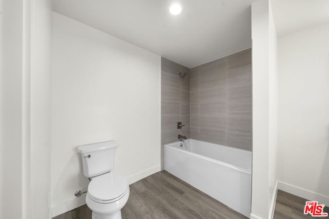 bathroom featuring hardwood / wood-style floors, tiled shower / bath combo, and toilet